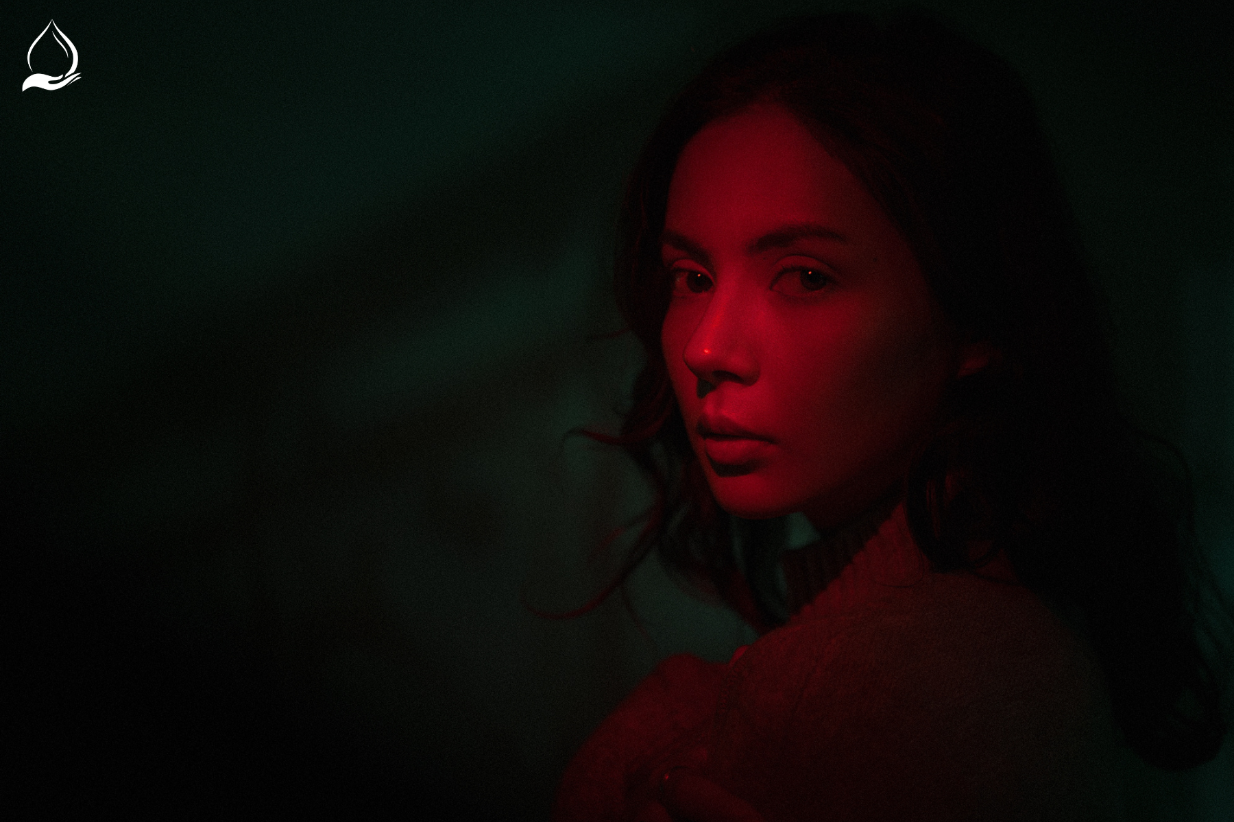 Young woman illuminated by red light, representing red light therapy benefits for skin rejuvenation and mood improvement